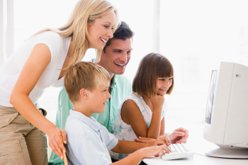 A family gathers at the computer to watch their video